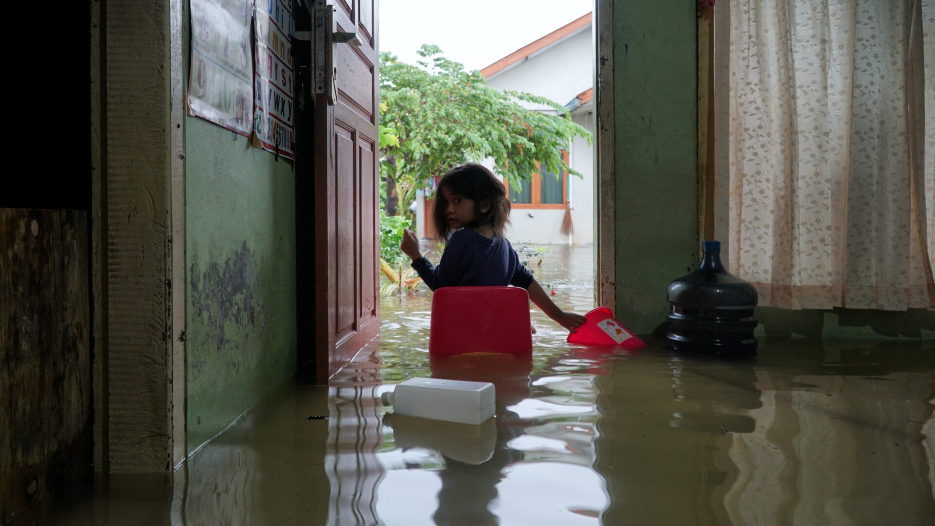 a-little-girl-sat-at-the-door-of-the-house-when-it-was-hit-by-a-flood_t20_KAg34K